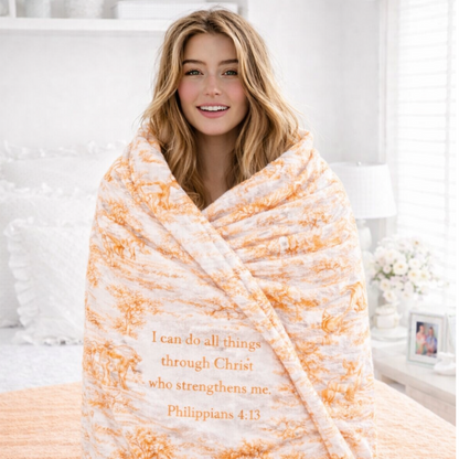 Woman wrapped in a blanket with a quote, sitting on a bed.